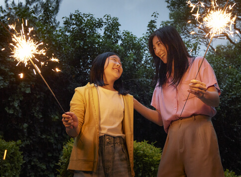 A portrait of mom and her daughter with sparklers